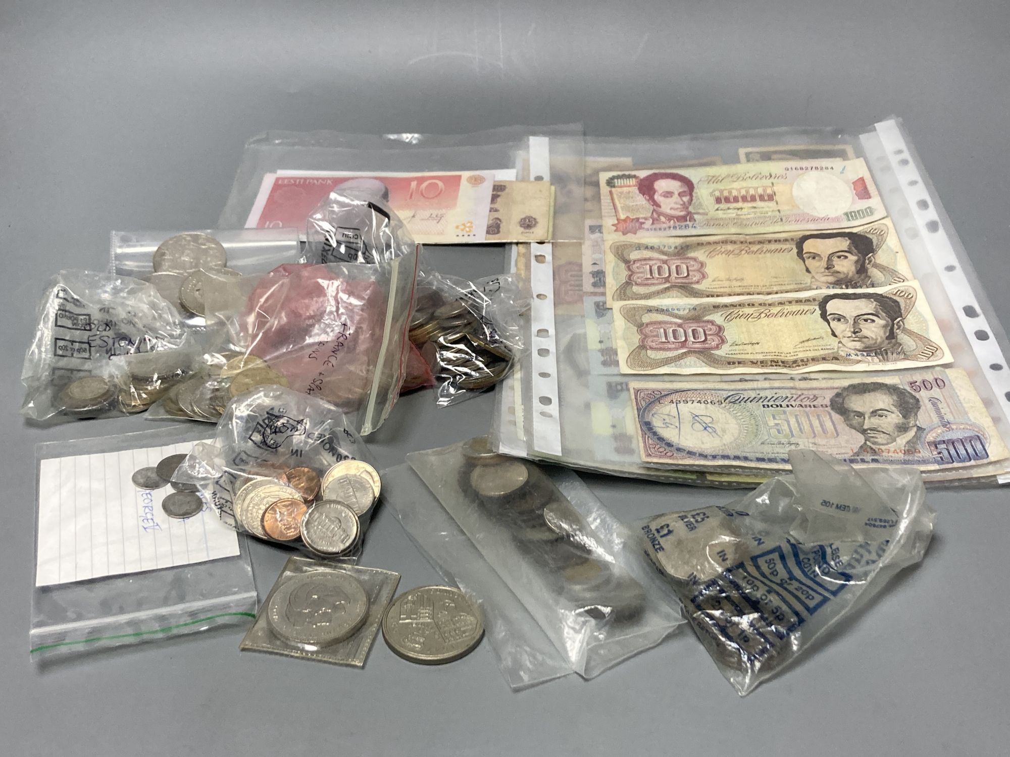 Various coins including Five Pounds coins and mixed world banknotes